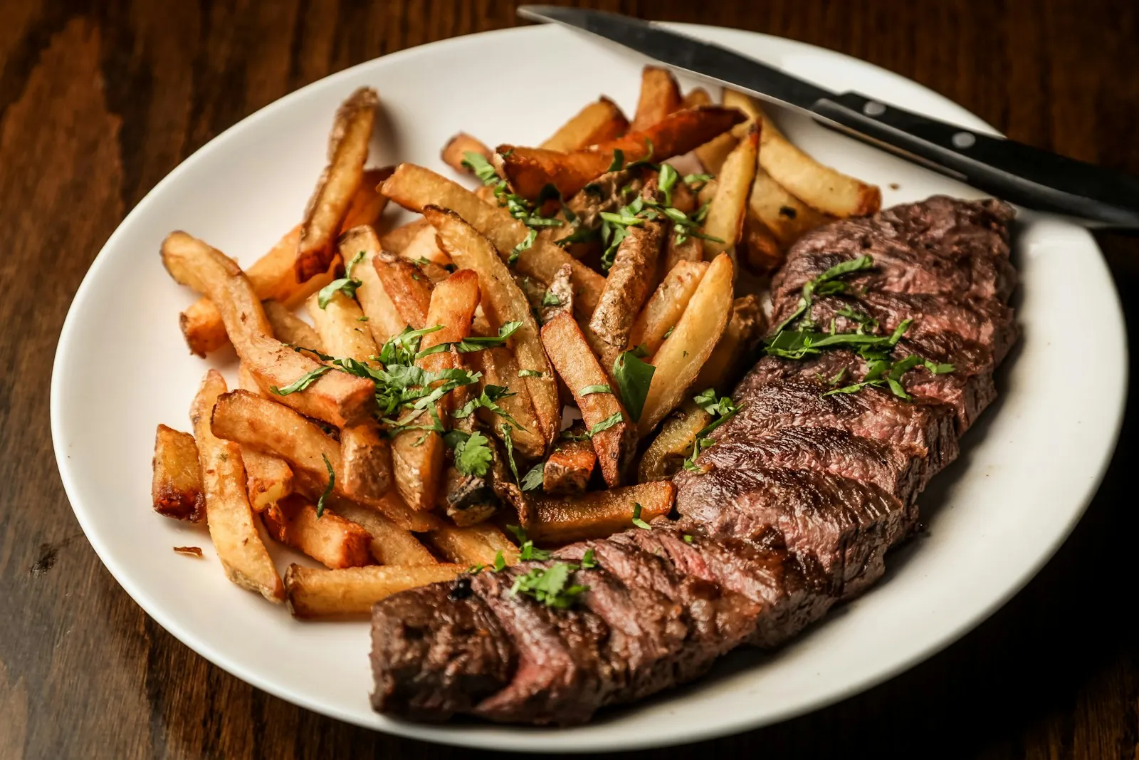 Zwiebelrostbraten mit Beilage auf dunklem Holztisch