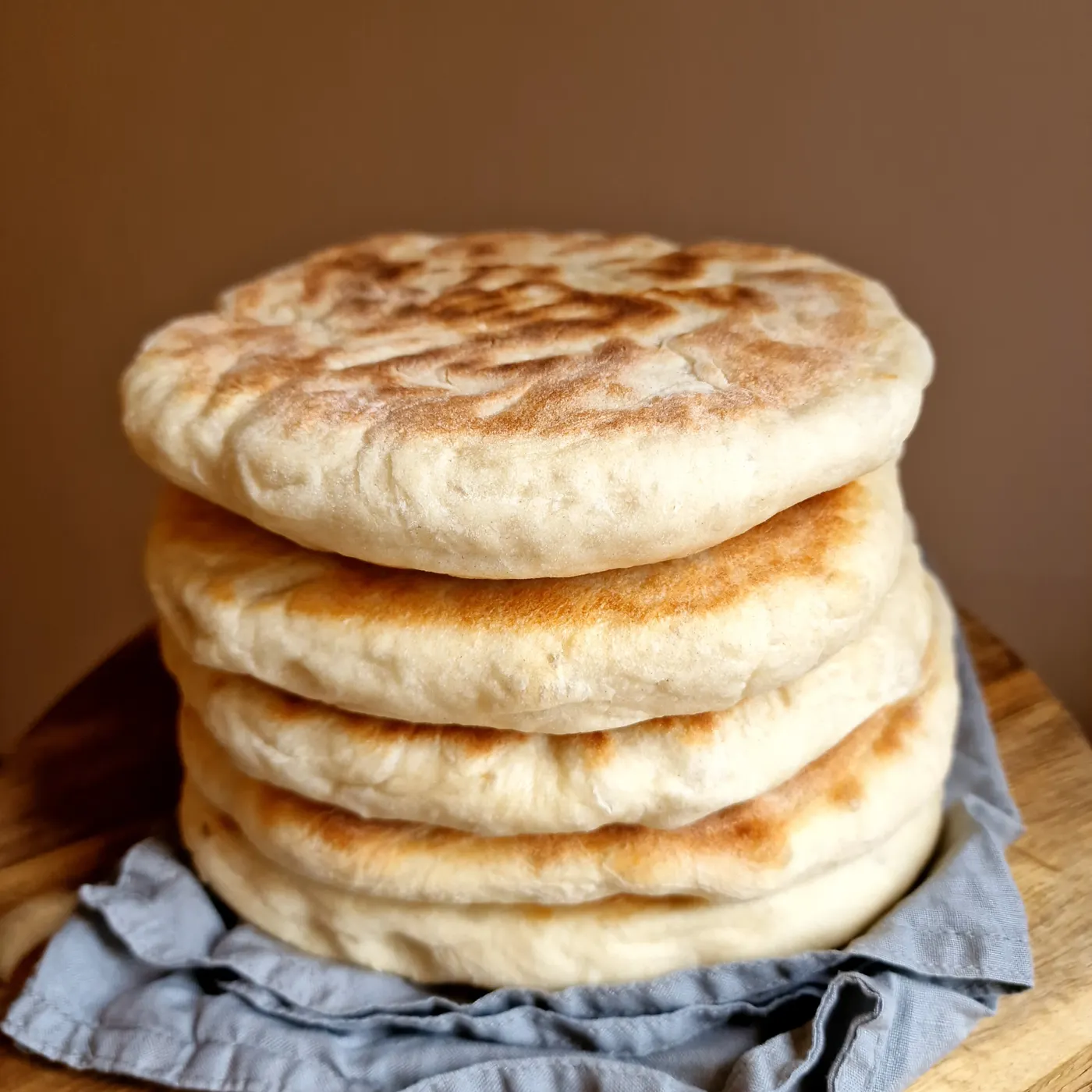 Stapel frisch gebackener Fladenbrote auf einem Holzbrett