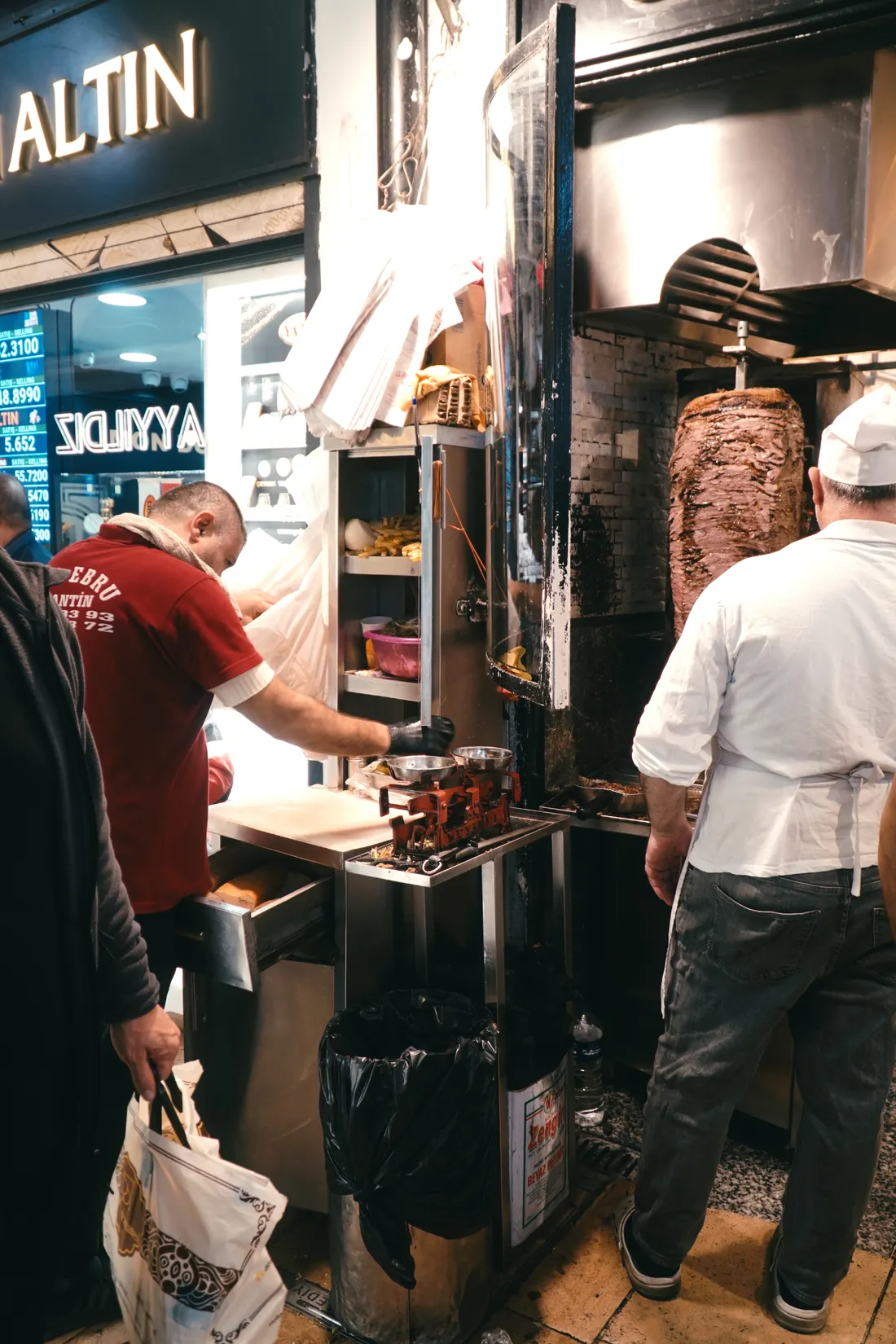 Abendlicher Dönerstand, zwei Männer arbeiten am Spieß
