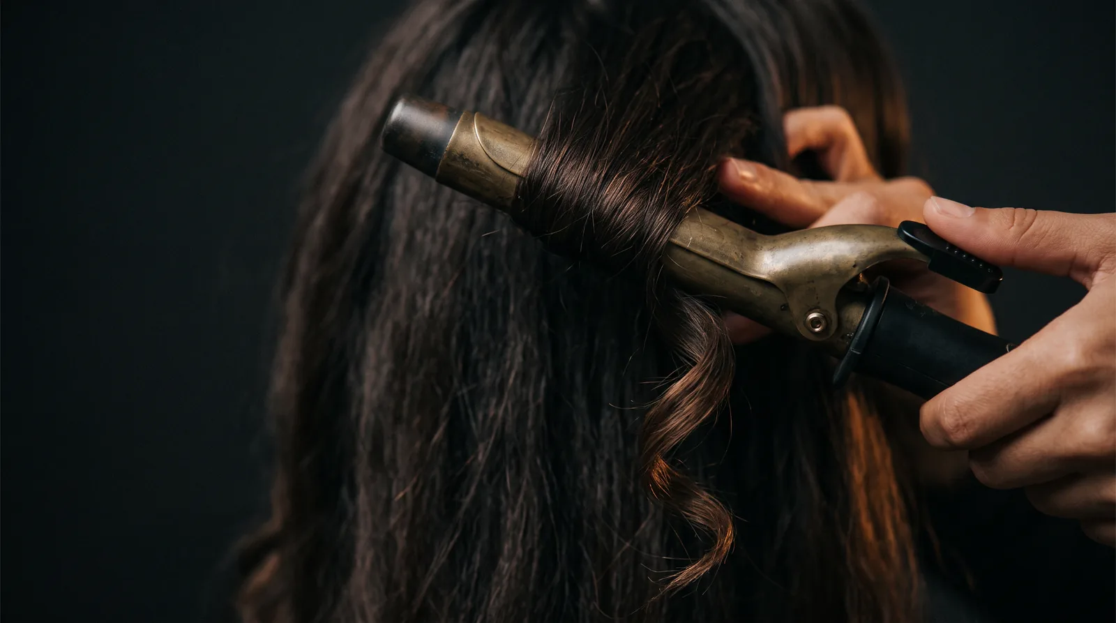 Locken werden mit dem Stylingeisen in Form gebracht, Nahaufnahme